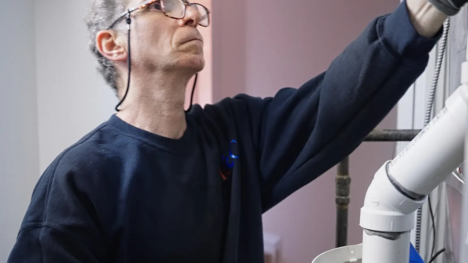 H&C technician working at a wall-mounted control