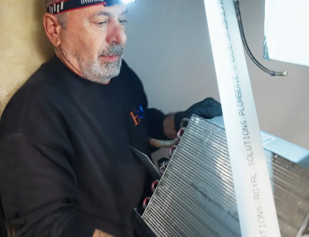 H&C technician carrying a new evaporator coil for a central air system